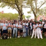 Group of diverse children and teens gathered outdoors at camp event.